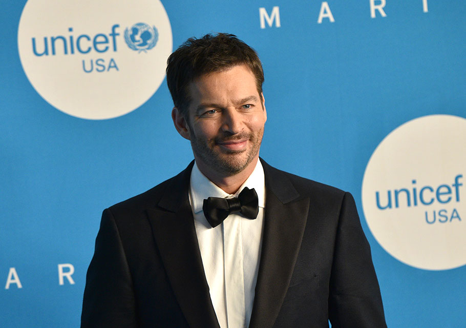 Harry Connick Jr. in a tuxedo, in front of a UNICEF USA branded backdrop