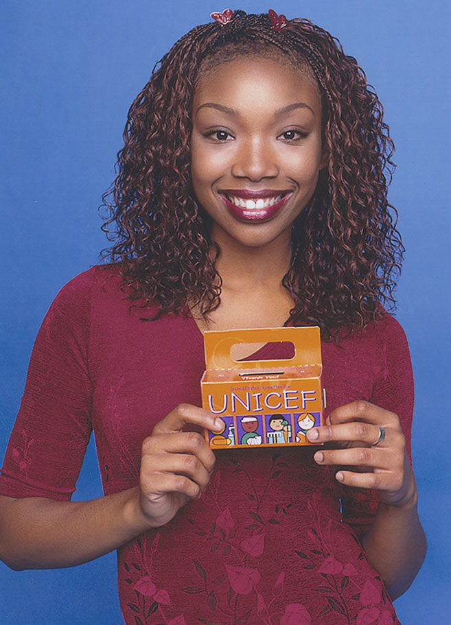 A portrait of Brandy holding the 50th Anniversary Trick-or-Treat for UNICEF box.