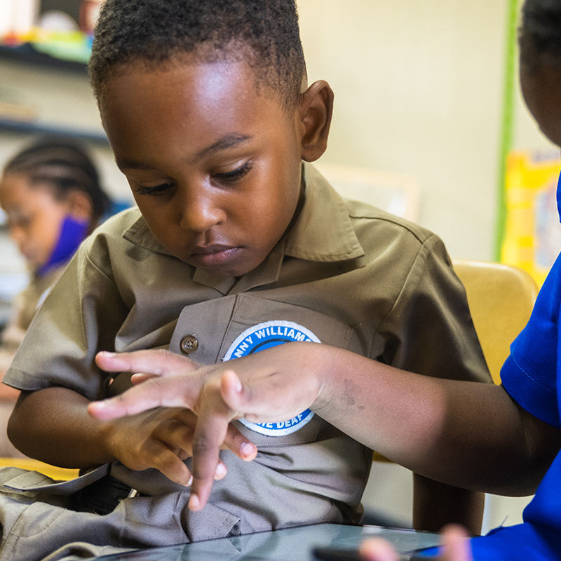 Ari, a hearing-challenged first grader in Jamaica, uses a digital book that includes sign language to help him learn to read.