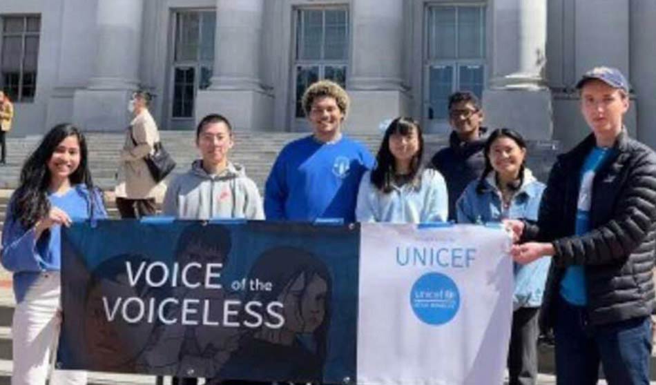 UNICEF Clubmembers hold up a banner that reads “Voices for the Voiceless” while gathering at the University of Cal—Berkeley.