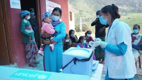 Volunteers talk to a mother holding a child