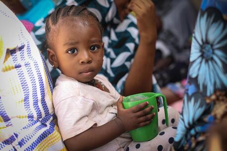 Kadidia, 23 months old, holds a cup of enriched porridge, which she was given during a nutrition demonstration in her community in Mali.