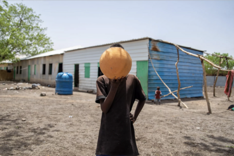 Displaced by the war in Sudan and separated from his family, Mohammed, 13, holds his beloved soccer ball in Gedaref. 