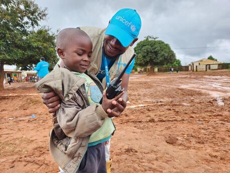 A UNICEF staff member shares a light moment with a young Cyclone Freddy survivor at the UNICEF-supported Naotcha camp for displaced families in Blantyre, Malawi, on March 17, 2023.