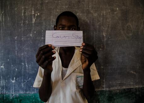 A student at a school in northeast Nigeria holds a paper showing his greatest fear, part of an exercise to identify strengths and vulnerabilities at school and in the community.
