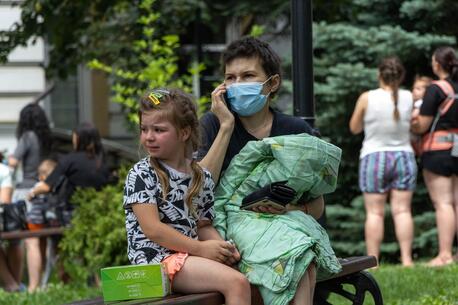 OnJuly 8, 2024 in Kyiv, a child sits on a bench and cries as rescuers, hospital staff and volunteers clear rubble and search for people trapped under debris after an attack that hit Okhmatdyt Hospital, Ukraine's largest children's medical center.