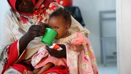 Seven-month-old Genan drinks after eating Ready-to-Use Therapeutic Food at Damazine Children's Hospital in Blue Nile State, Sudan.