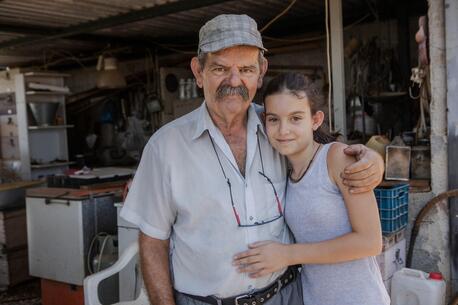 Markos Sakarikos, 70, a pensioner and a beekeeper from Nea Makri, Greece, with his granddaughter Markela..