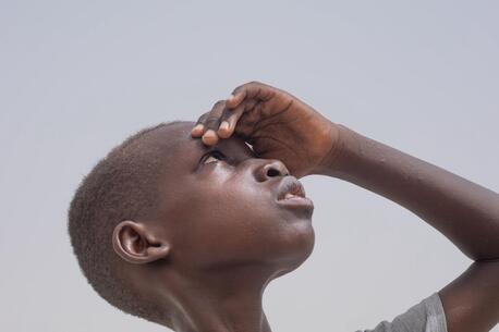 Ali Taha Yousif, 10 years, sweats under the scotching sun in Sudan.