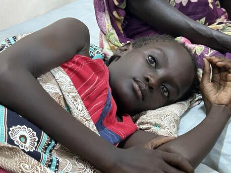 Narmin, 10, lies in a bed at Al Nau hospital in Khartoum where she is being treated for an injury suffered during a shelling.