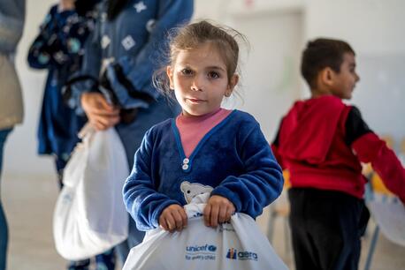 A girl holds a UNICEF winter clothing kit in southern Lebanon. 