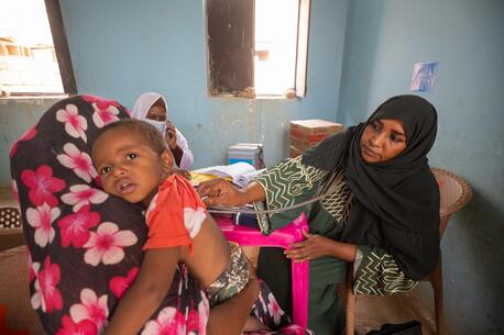 A mother brings her child for treatment at a UNICEF-supported mobile clinic in Adama locality, Atbara, River Nile state, Sudan. 