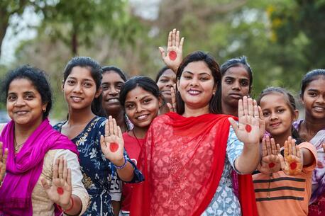 Payal Patel, who has developed a basket of affordable and sustainable menstrual products for women, poses with women and girls in Odisha, India.