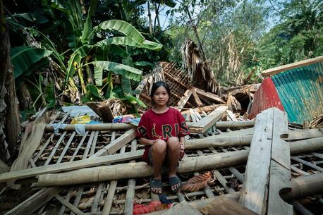 On Sept. 26, 2024, Hoang Thi Tuyet Nhung, 13, sits on the ruins of a house destroyed by a landslide caused by Typhoon Yagi in Thuong village, Yen Bai province, Vietnam.