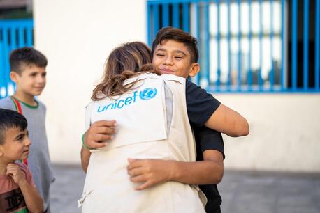 Mohammad, 13, is comforted by a UNICEF staff member outside a shelter in Beirut for families displaced by war.