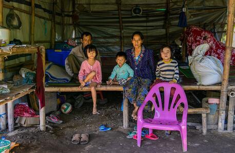 A family displaced by conflict in Kachin State, Myanmar, sits inside their makeshift room at the Shamari IDP camp in Myitkyina, where Deputy Executive Director Ted Chaiban paid a visit to witness impacts of the ongoing humanitarian crisis in the country.