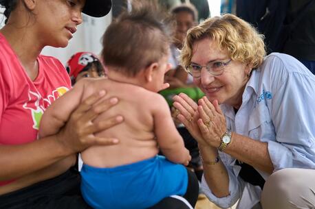 Karin Hulshof, UNICEF Regional Director in Latin America and the Caribbean, plays with a baby at a respite center for migrating families in Darien, Panama.