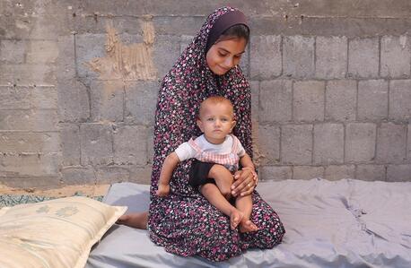 Sahaed Kashko, a mother from Gaza, holds her young daughter, who suffers from malnutrition.