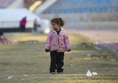 On Dec. 4, 2024, in Ar-Raqqa city, Syria, a young girl stands outside a UNICEF-supported reception center for families displaced by escalating violence in Aleppo.