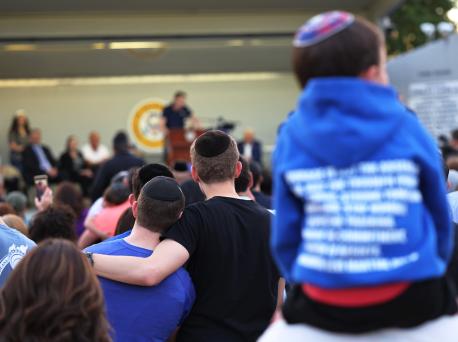 People listen to Joseph Borgen, a recent victim of a hate crime, speak during a rally denouncing antisemitic violence on May 27, 2021 in Cedarhurst, New York. 
