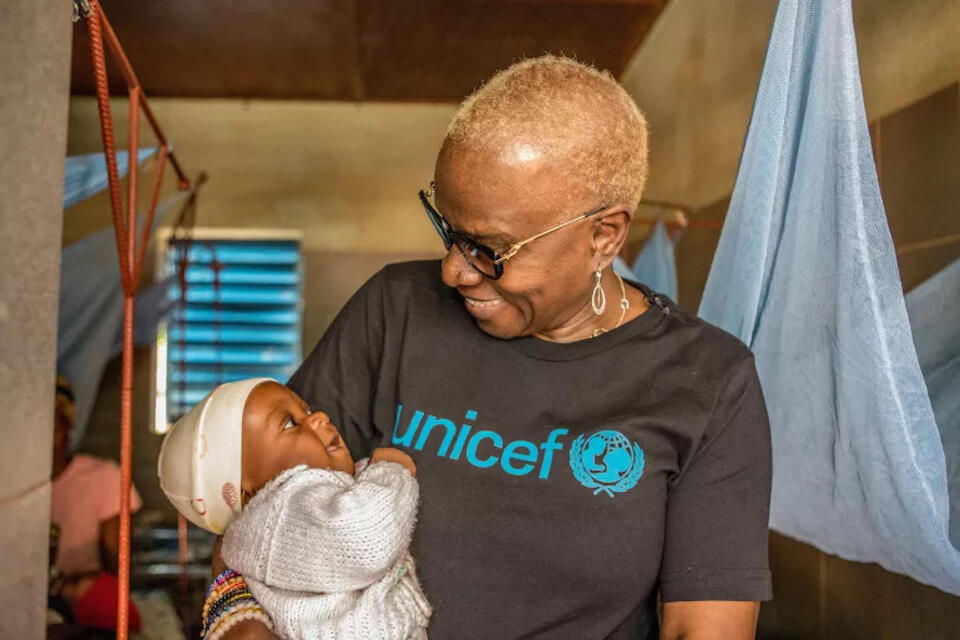 On Dec. 15, 2022, UNICEF Goodwill Ambassador Angélique Kidjo holds a child who is being treated for malnutrition at the Center for Therapeutic Nutrition at Saint Jean de Dieu Hospital in Tanguiéta, northern Benin.