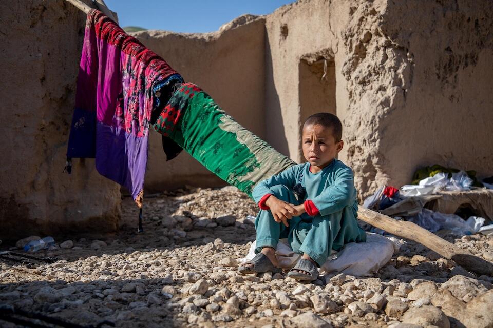 On May 14, 2024, Deen Mohammad, 8, sits where his home used to be in Shaikh Jalal Village, Baghlan-e-Jadid District, Baghlan Province, Afghanistan.