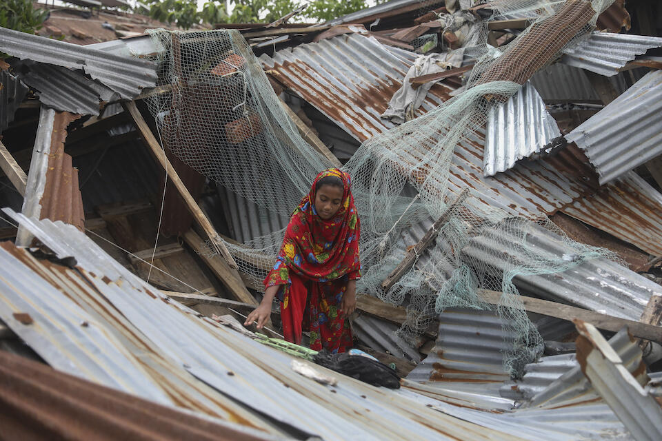 Jannatul, 13, tries to salvage her books from her damaged home in Patuakhali, Bangladesh, on May 28, the day after Cyclone Remal’s devastating landfall.