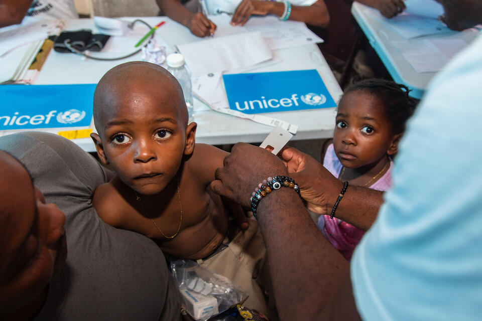 A child is screened for malnutrition by a member of a UNICEF-supported mobile health unit providing health and nutrition services at a camp for internally displaced families in Port-au-Prince.