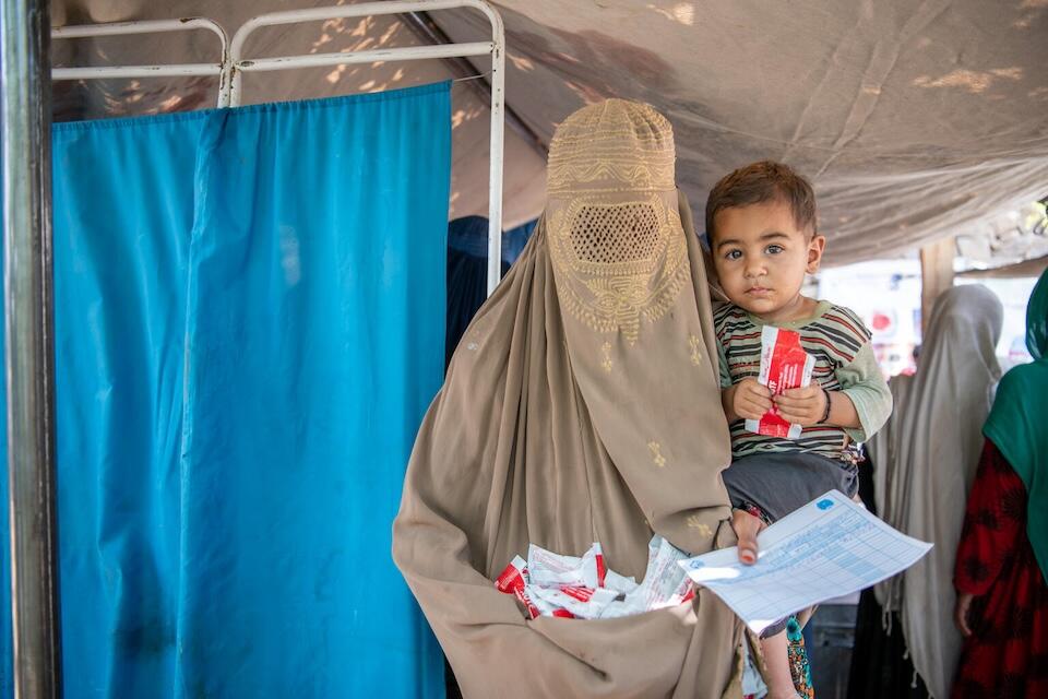 A mother receives Ready-to-Use Therapeutic Food from a UNICEF-supported mobile health and nutrition team in Samsagal village, Nari District, Kunar, Afghanistan.