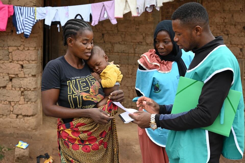 A mother receives a birth certificate for her youngest child in the village of Bindi, in the East region of Cameroon. 