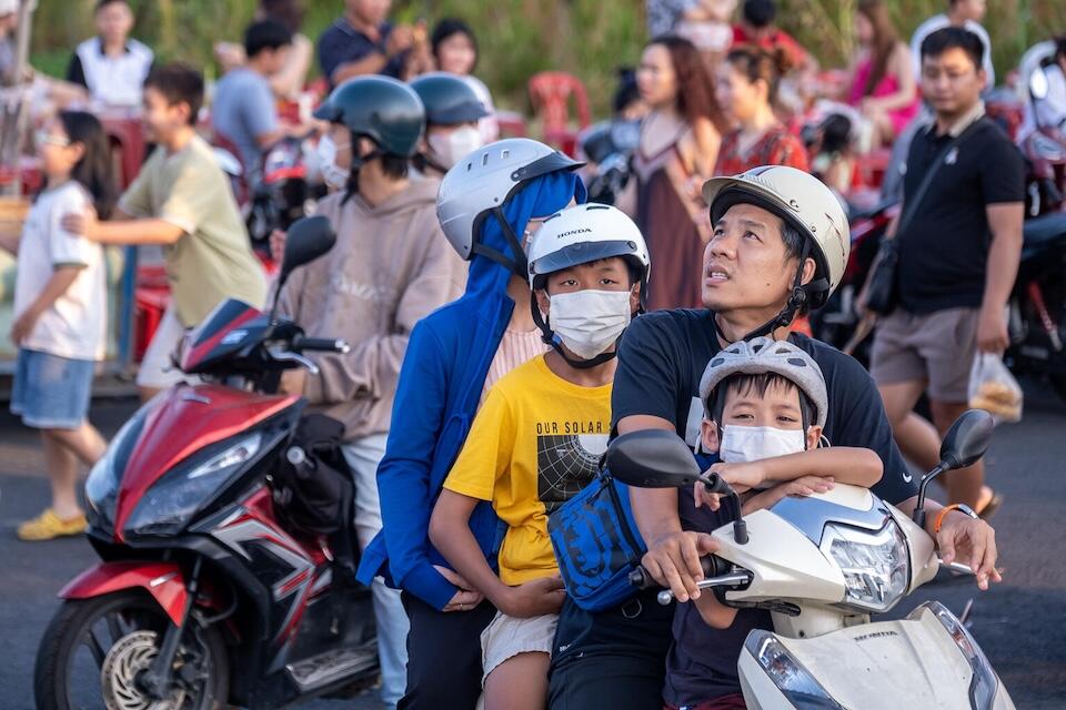 Children wear masks when traveling by motorbike with their family in Hi Chi Minh City, Vietnam.