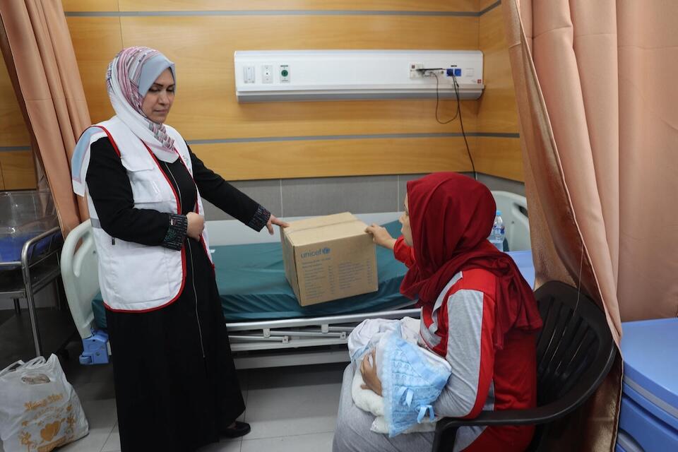 Widad and her newborn son, Mahmoud, received essential baby supplies and clothing distributed by UNICEF in the Gaza Strip..