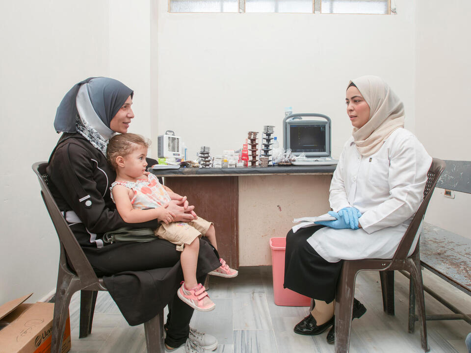 Zainab, 38, holds her daughter Athinat while chatting with her gynecologist at a UNICEF-supported health and nutrition mobile clinic in Rural Damascus, Syria, on July 18, 2024.