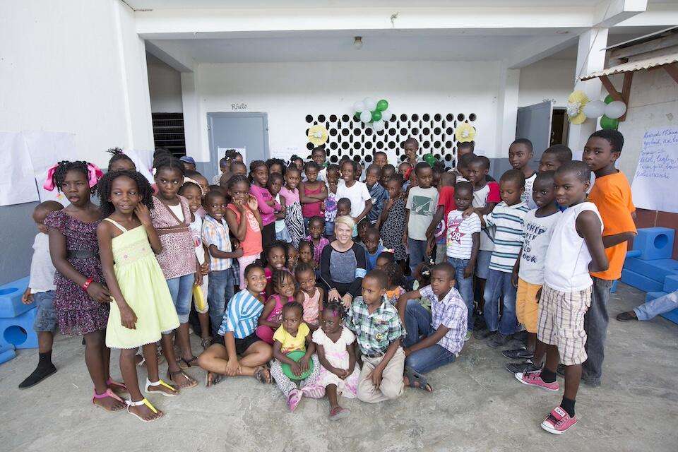 P!nk, UNICEF Ambassador since 2015, sits surrounded by schoolchildren at a UNICEF-supported school in Haiti.