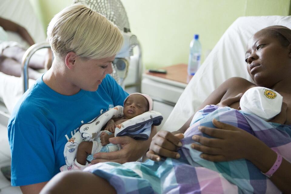 P!nk, UNICEF Ambassador since 2015, holding a newborn baby by the hospital bedside of a new mom practicing kangaroo care with the baby's twin, at a UNICEF-supported hospital in Haiti.