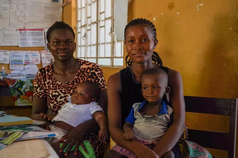 Esther Conteh, left, and Magaret Conteh wait to get their children vaccinated at the Kapethe Maternal and Child Health Post north of Makeni, northern Sierra Leone.