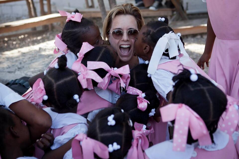 Téa Leoni, UNICEF Ambassador, surrounded by a group of girls during a program visit.