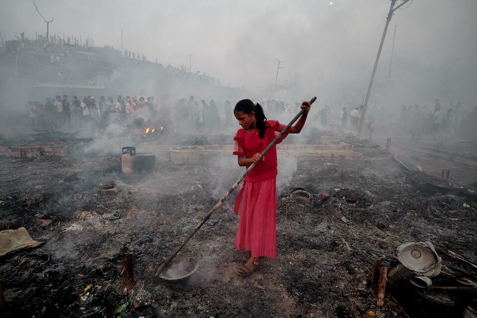 On March 5, 2023, a girl is seen searching for her belongings amid the ruins left by the fire that broke out in Balukhali refugee camp in Ukhia, Cox's Bazar, Bangladesh.