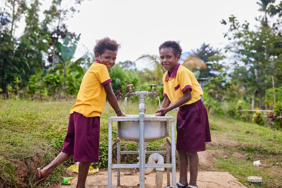 Two students use the new WASH facilities at their school in a remote mountain village in the Morobe Province of Papua New Guinea. 