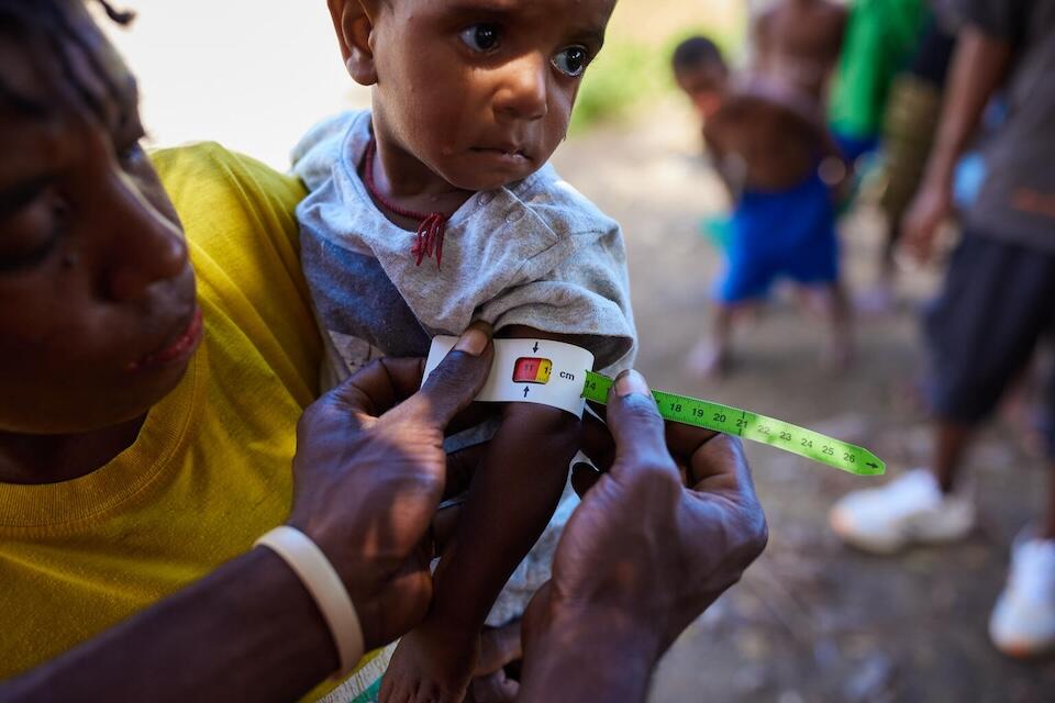 A VIllage Health Assistant in Papua New Guinea goes door-to-door in local communities to screen babies and young children for malnutrition.