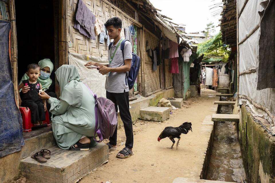 Two nutrition volunteers trained by UNICEF going door to door stop at the home of Noor Bibi, 28, and her daughter Jishan, 2, to provide support.