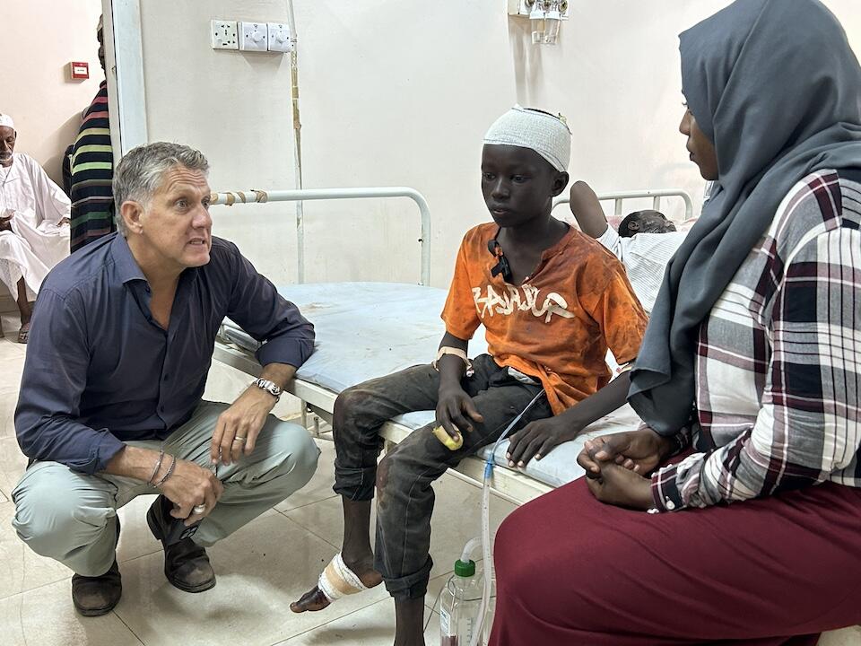 UNICEF Spokesperson James Elder speaks to 13-year-old Abu who was injured by shrapnel from a shelling while playing football at a UNICEF child-friendly space in Al Hattana in Khartoum, Sudan.