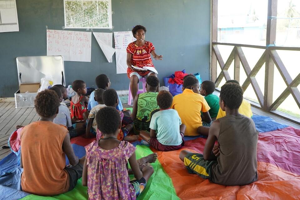 A volunteer at a care center in Angoram, where survivors of the massacre in East Sepik are being cared for, offers learning sessions to children.