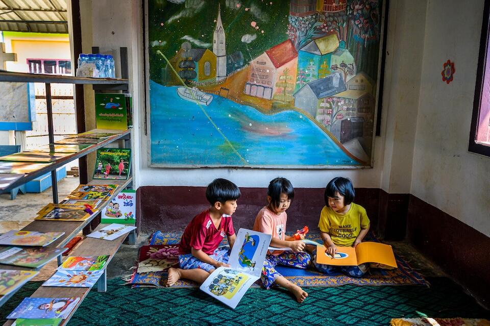 Children read storybooks written in their ethnic dialect at a UNICEF-supported learning hub in Paraditu village, Mong Yawng township, eastern Shan State, Myanmar. 