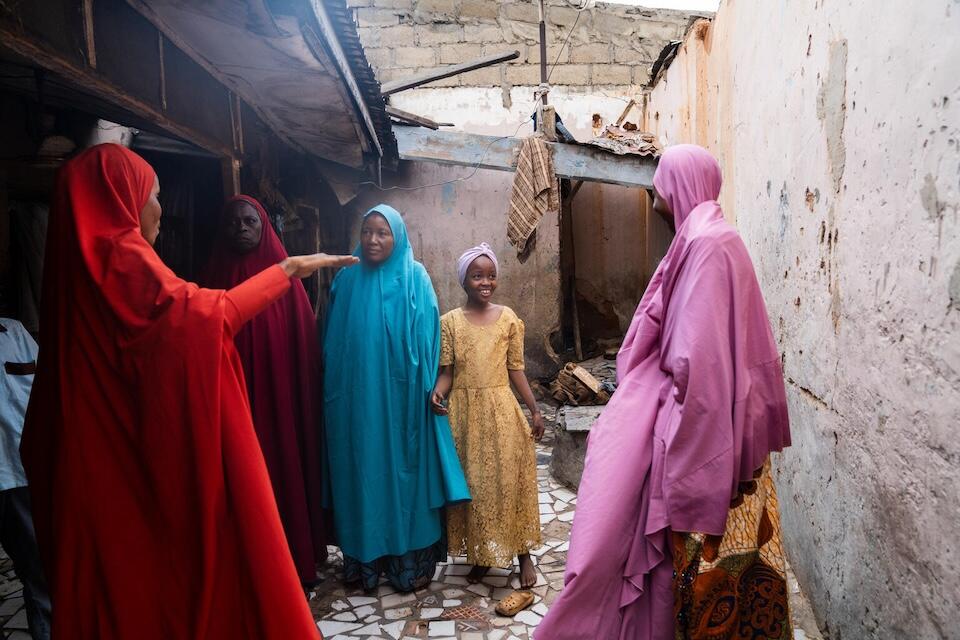 A volunteer community mobilzer, far left, speaks with the family of Safiyya, 10, about the human papillomavirus (HPV) vaccine.