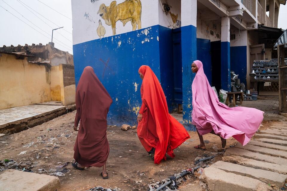 A UNICEF-supported volunteer community mobilizer, center, and her sisters venture out to educate local families with girls aged 9-14 about HPV vaccination in Katsina, Nigeria.  