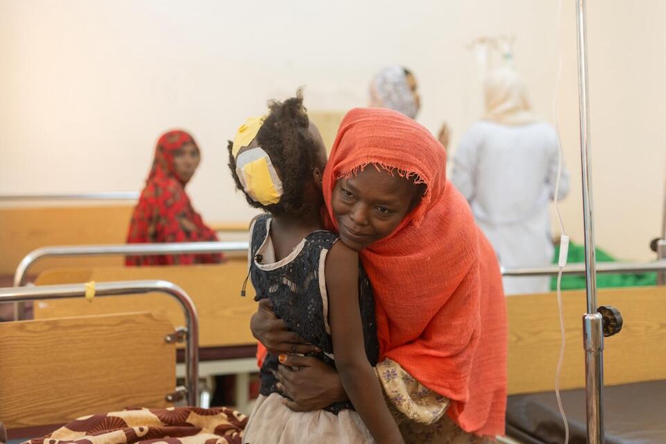 Samah hugs her 8-year-old daughter, Fatima, who is recovering from a gunshot wound to the head in a UNICEF-supported hospital in northern Sudan. 