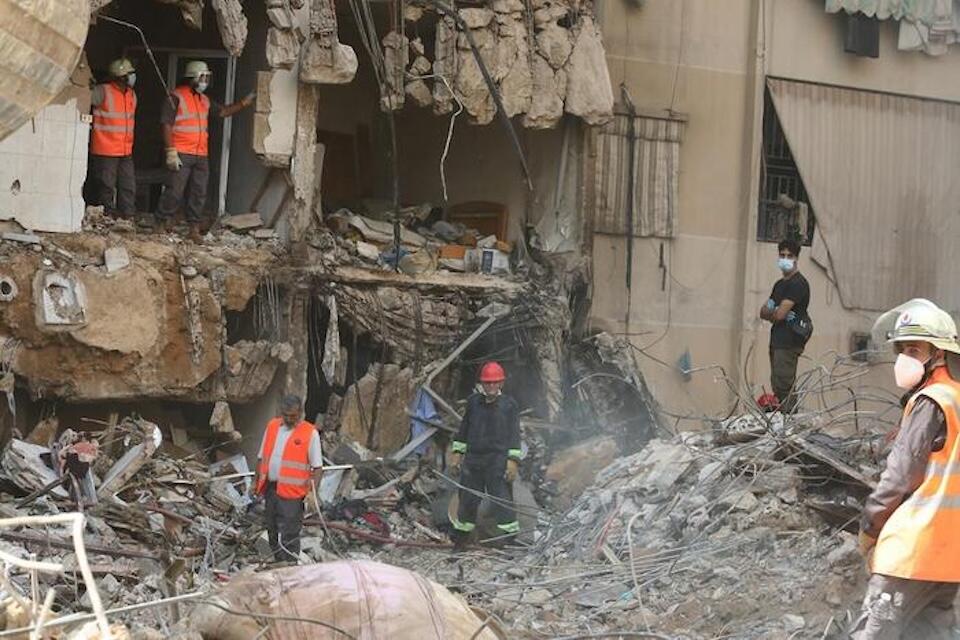 Workers assess the destruction following an air strike on Beirut's southern suburbs on Sept. 20, 2024.