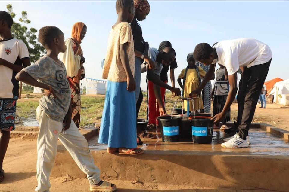 In flood-affected Chad, children gather at a UNICEF-supported water access point to collect safe water for themselves and their families.