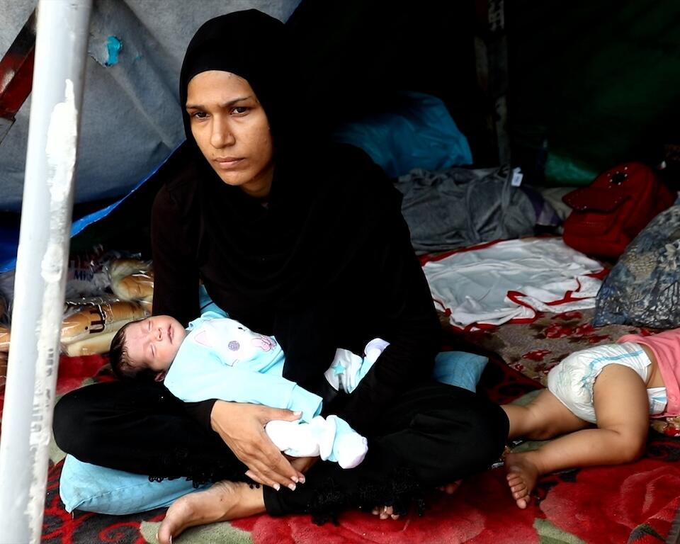 A mother and her young children are living in a makeshift tent in downtown Beirut after being displaced by air strikes. 